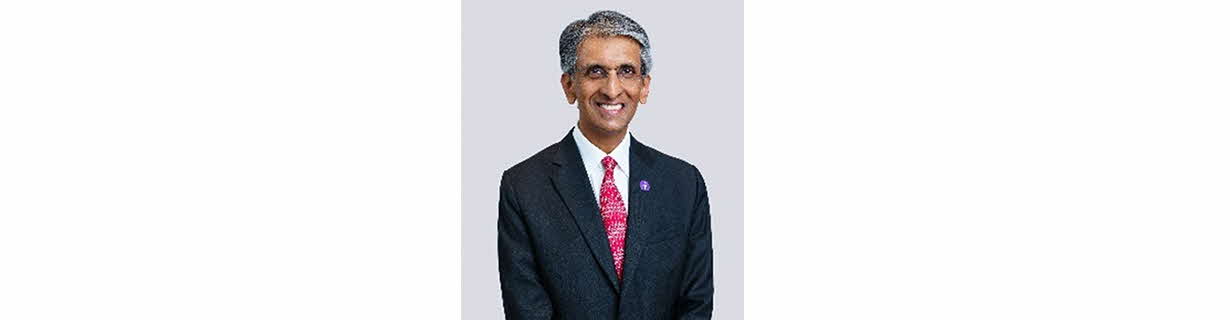 Portrait of Dilhan Pillay, man in black business suit and red tie, smiling